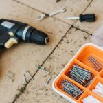 From above of assorted carpentry tools in plastic case placed with metal hammer and screwdriver